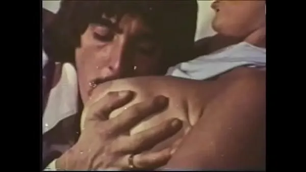 A mustachioed dude with long sideburns caresses an experienced blonde with huge buckets in a 70s video Video terbaik baharu